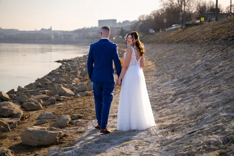 Menyasszony és vőlegény sétál a Duna köves partján