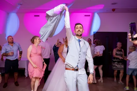Vőlegény és menyasszony az esküvői táncparketten, színes fények között