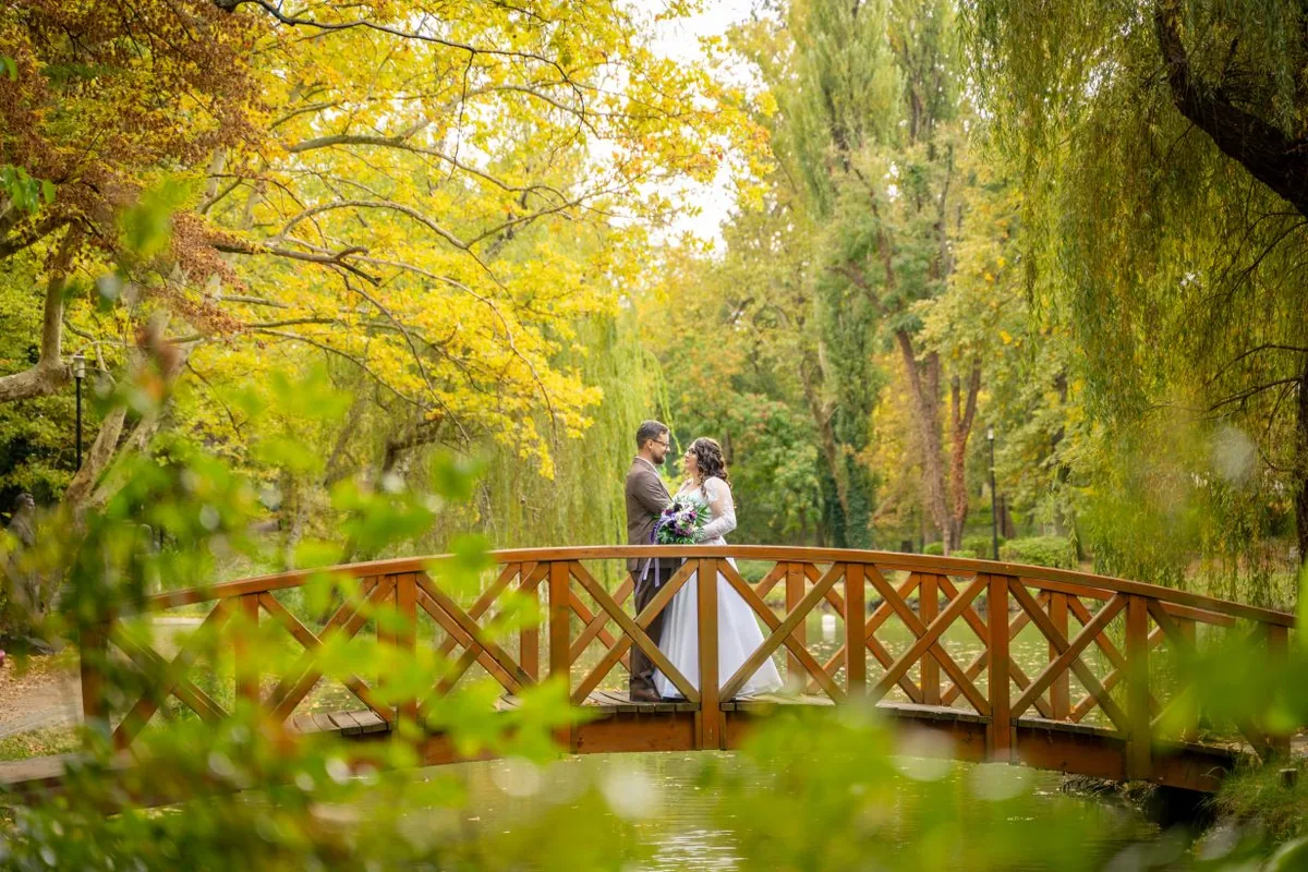 Esküvői pár a tatabányai Tulipános Rendezvényház parkjának őszi fahídján
